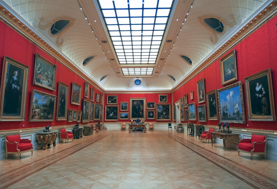Elegant art gallery in London displaying classic paintings on red walls under skylit ceiling.