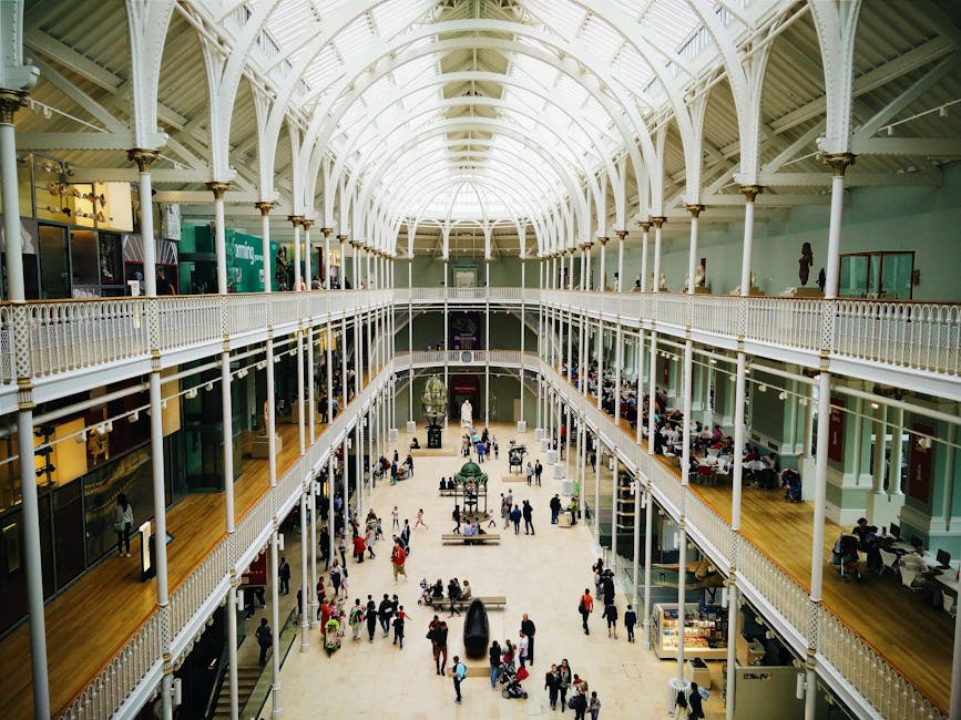 Interior view of the National Museum of Scotland's grand hall with visitors exploring exhibits.